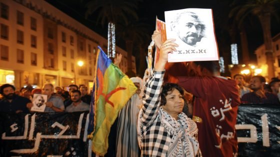 epa06011034 Protesters hold a placard depicting Nasser Zafzafi, leader of the protest movement in the Rif region, and an Amazigh Flag during a demonstration in solidarity with the Rif region and against corruption, repression and unemployment in Rabat, Morocco, 05 June 2017. EPA/ABDELHAK SENNA